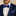 Man wearing a navy suit with a colorful polka dot bow tie and pocket square.