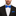 Man wearing a black suit with a blue bow tie and pocket square on a white background