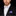Man wearing a black suit with a colorful bow tie and pocket square on a black background