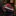 Red and Brown black patterned tie on a reflective surface with blurred background