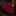 Red and black patterned tie on a dark surface with a blurred background