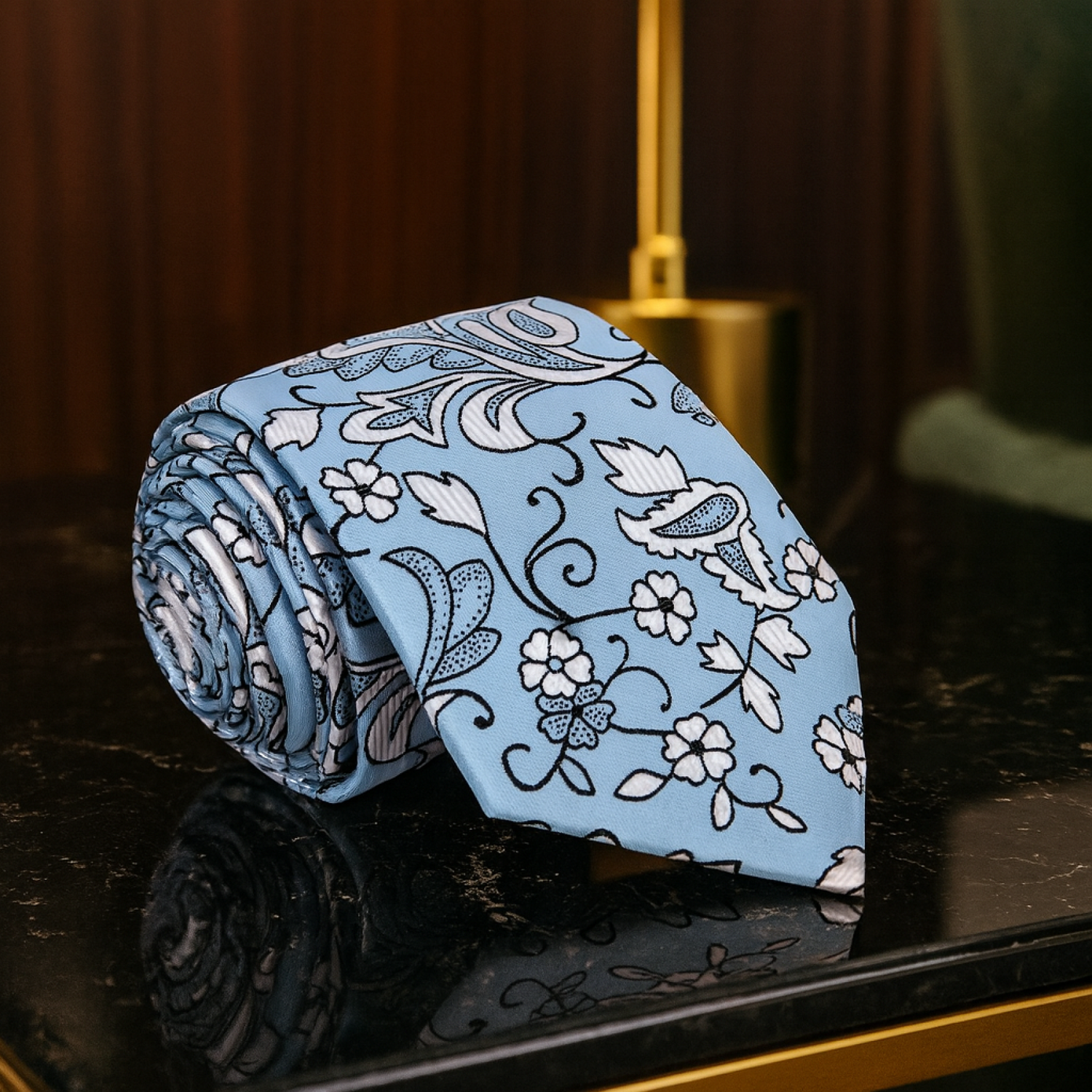 Blue floral patterned tie on a dark surface with a blurred background