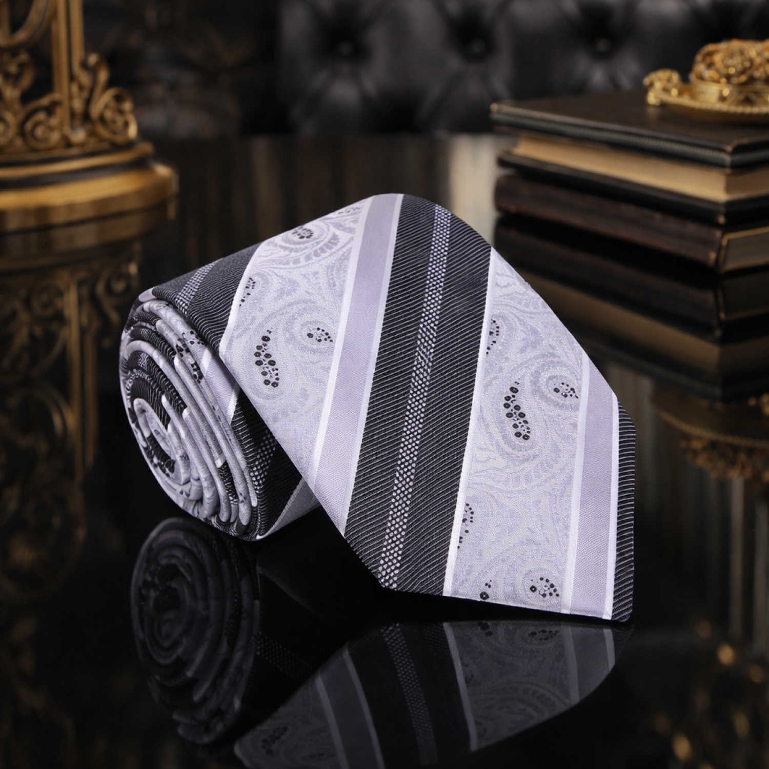 Roll of black and white patterned fabric on a reflective surface with a dark background