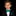 Young boy in a black suit with a green bow tie and pocket square on a black background