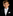 Young boy in a formal black suit with white bow tie and pocket square on a black background