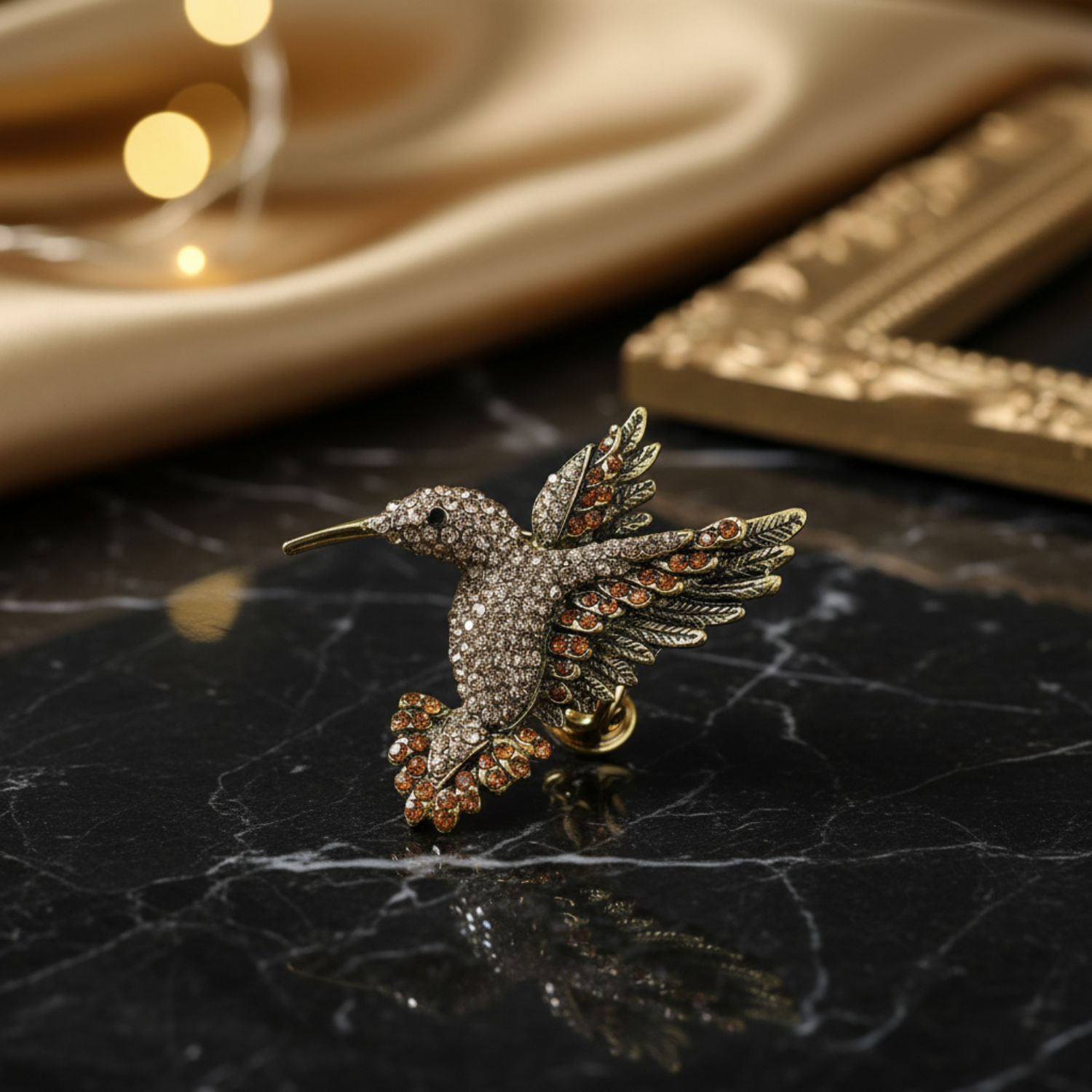 Decorative hummingbird brooch with brown and gold details on a blurred background