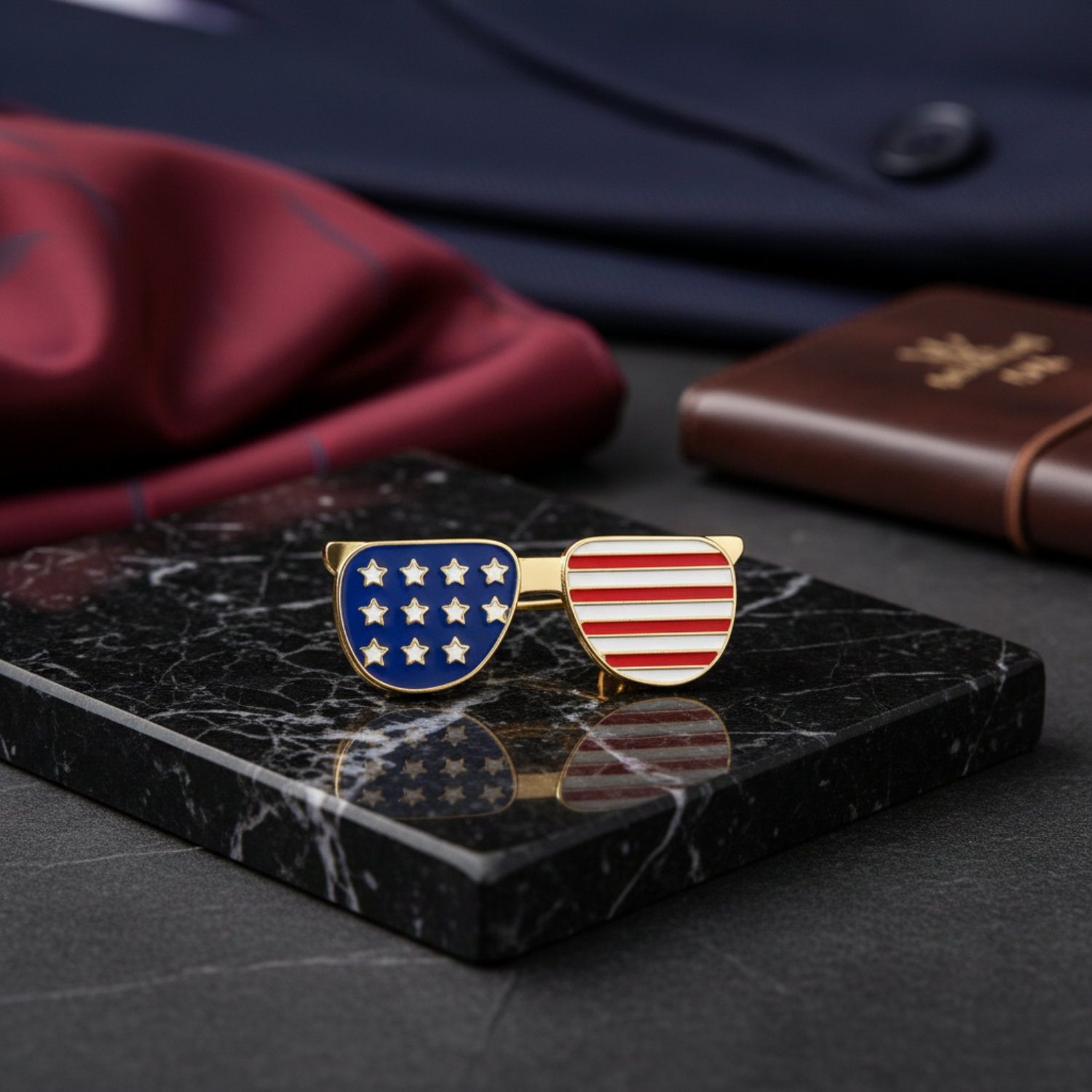 Sunglasses-shaped pins with American flag design on a dark surface
