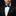 Man wearing a black tuxedo with a blue bow tie and pocket square on a black background