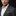 Man wearing a gray suit with a checkered pocket square on a black background