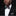 Man wearing a black suit with a white shirt and polka dot bow tie and pocket square.
