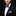 Man wearing a black suit with a patterned bow tie and pocket square on a dark background