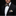 Man wearing a black suit with a colorful bow tie and pocket square against a black background