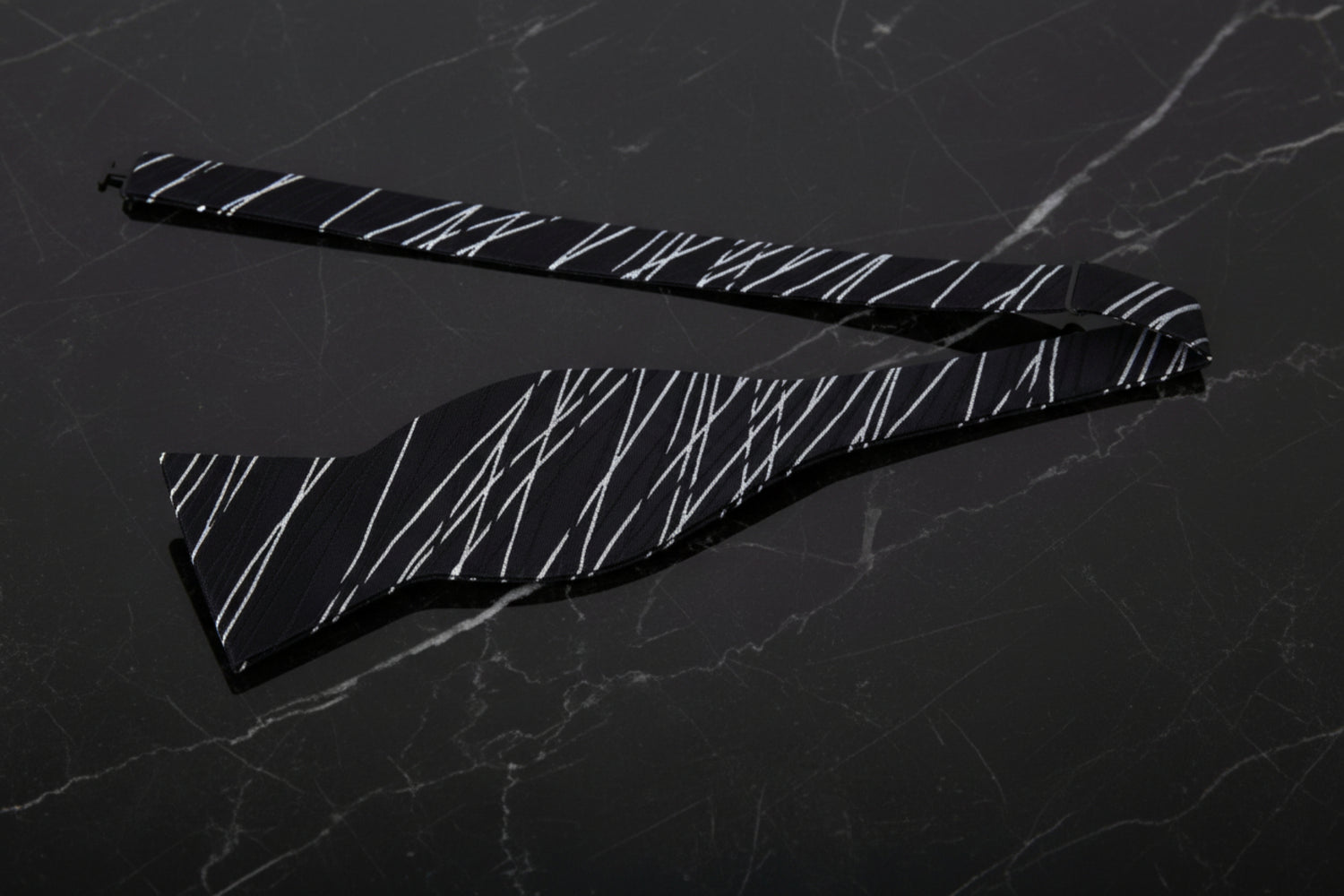 A Black, White Abstract Intersecting Lines Pattern Self Tie Bow Tie