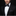 Man wearing a black tuxedo with a bow tie and pocket square on a dark background