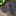 Navy patterned tie and pocket square on a wooden surface with greenery in the background