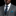 Man wearing a gray suit with a blue tie and pocket square on a black background