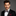 Man wearing a black suit with a bow tie and pocket square on a gray background