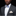 Man wearing a gray suit with a white shirt and colorful bow tie against a black background