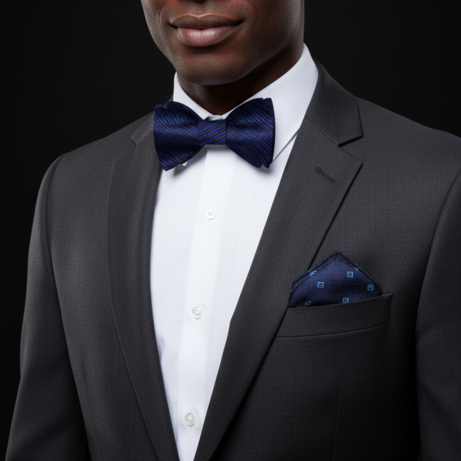 Blue striped bow tie and accenting pocket square on a man with a white shirt.