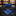 A blue, black, and yellow silk bow tie with a floral 'Tulips at Midnight' pattern laid out on a wooden surface.