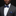 Man wearing a gray suit with a blue bow tie and pocket square against a black background