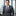 Man in a gray suit with a patterned tie standing in an office setting