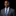 Man wearing a gray suit with a blue tie and pocket square on a black background
