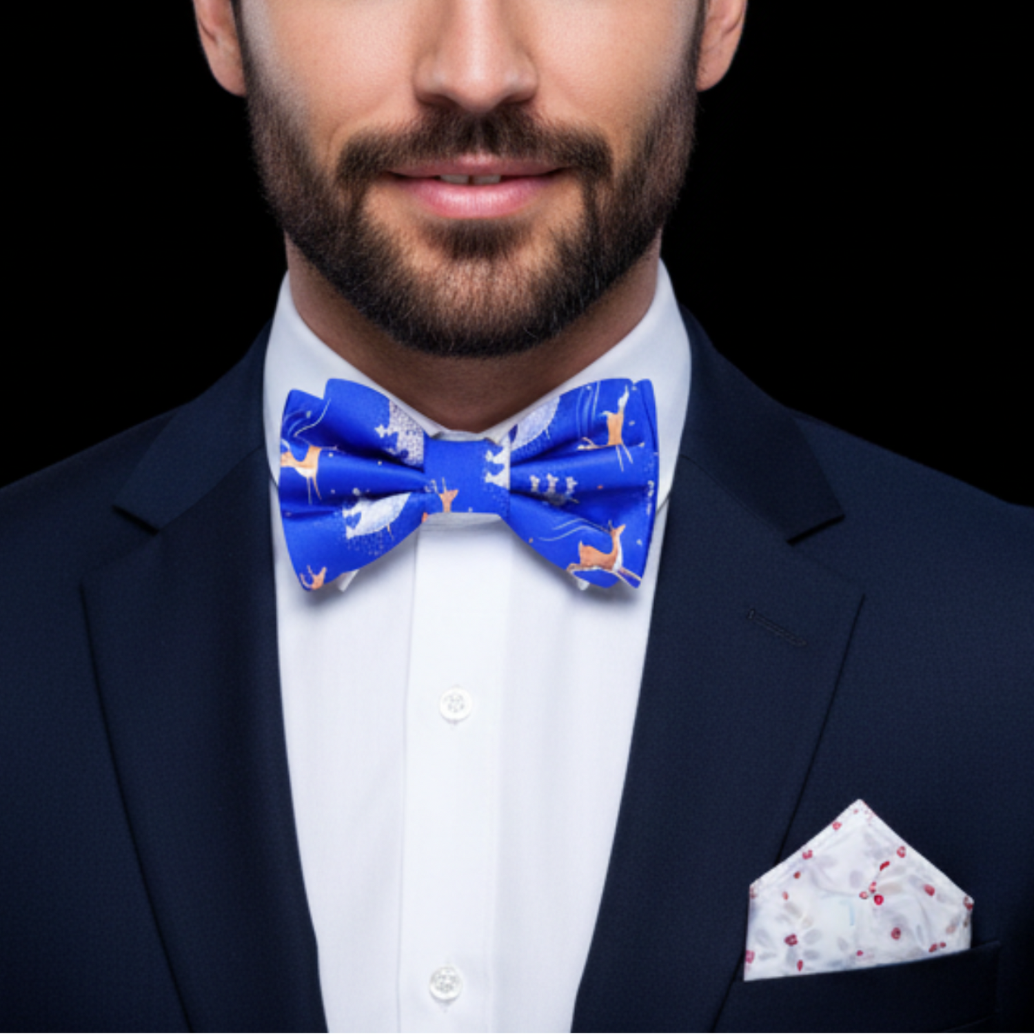 Man wearing a blue bow tie and accenting pocket square against a black background