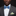 Man wearing a gray suit with a blue bow tie and green pocket square on a black background