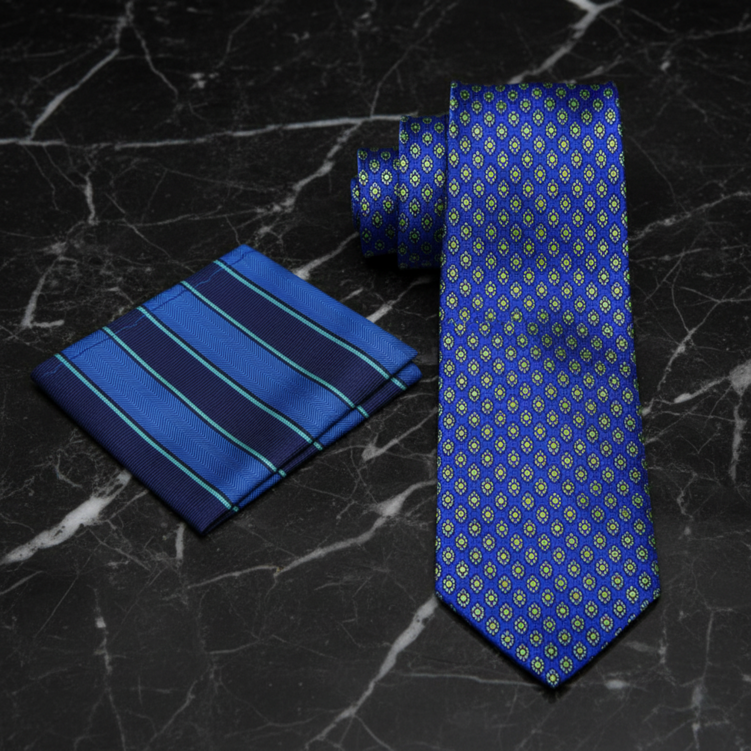 Blue tie with yellow pattern and blue striped pocket square on a white background