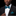 Man wearing a black suit with a green striped bow tie and pocket square on a black background