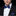 Man wearing a black suit with a white shirt, blue bow tie, and matching pocket square.