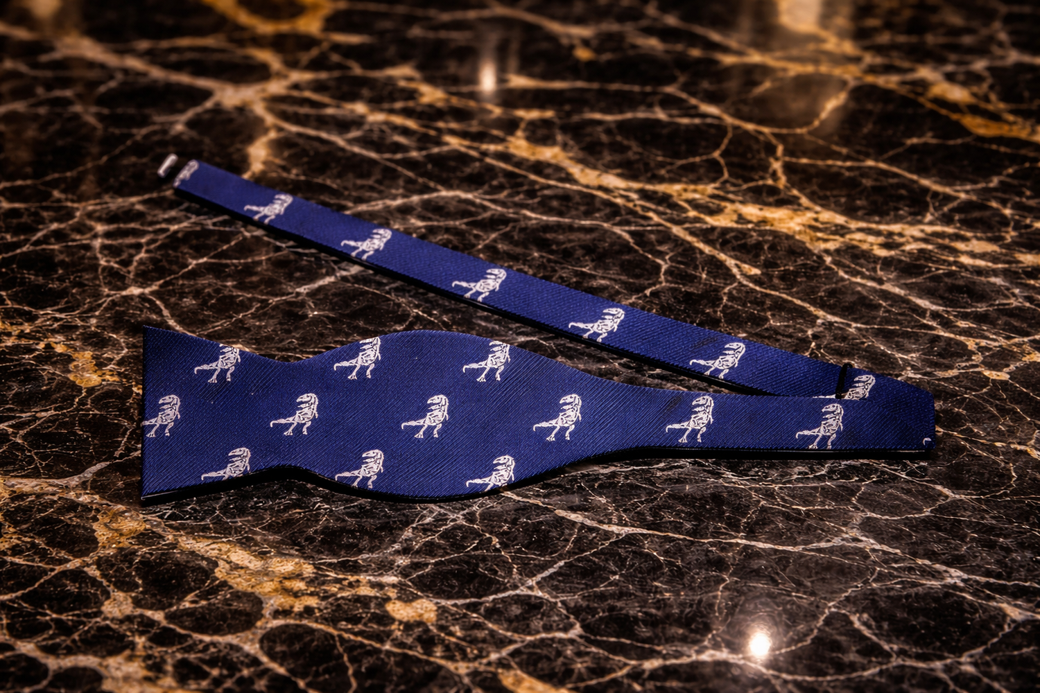Blue bow tie with white patterns on a marble surface