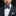 Man wearing a dark suit with a patterned bow tie and pocket square on a black background