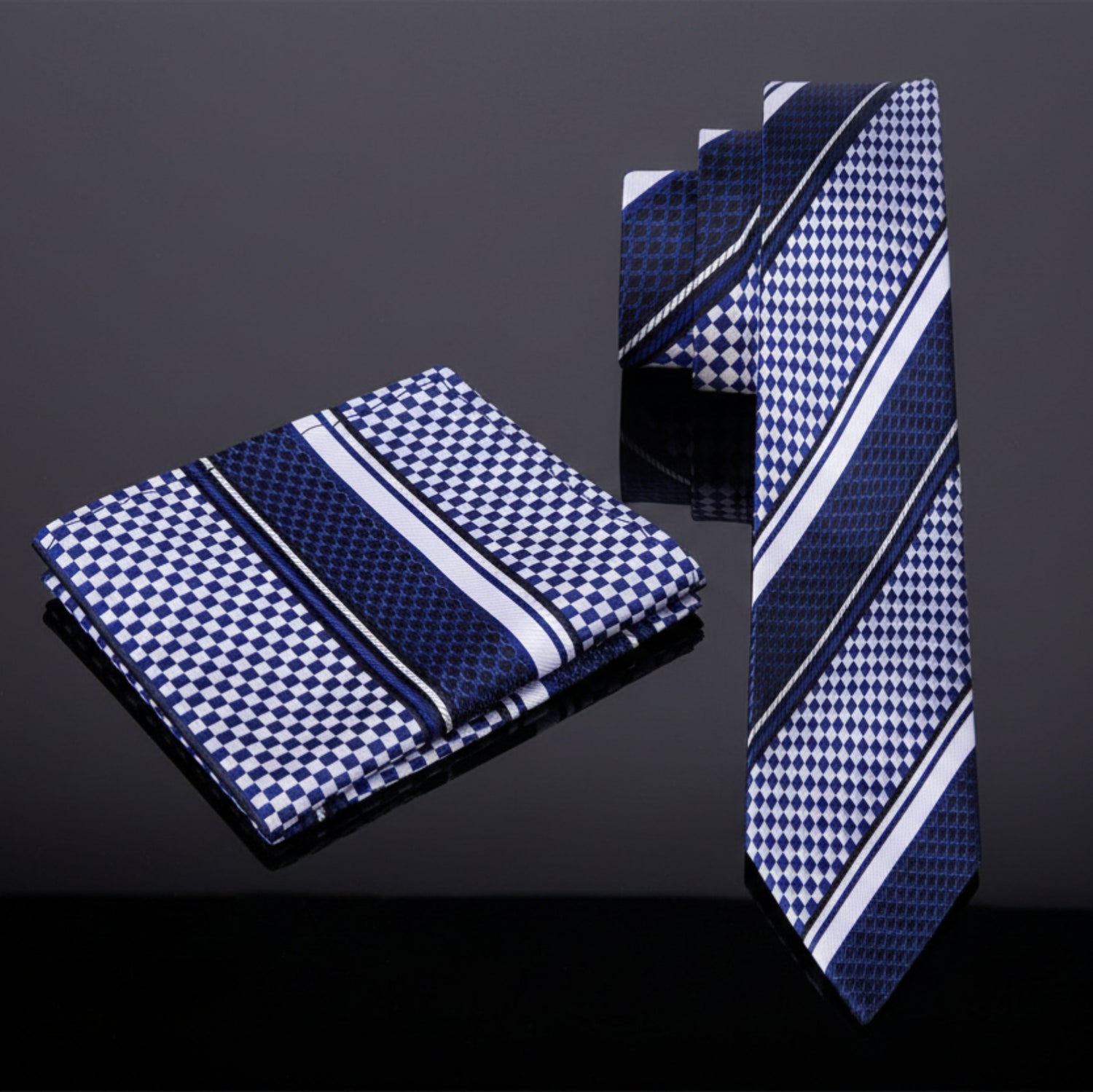 Navy blue and white patterned tie and pocket square set on a white background