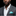 Man wearing a gray suit with a white shirt and turquoise pocket square on a black background