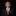 Young boy in a suit with an orange and blue striped tie on a black background