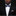 Man wearing a black suit with a colorful bow tie and pocket square against a black background