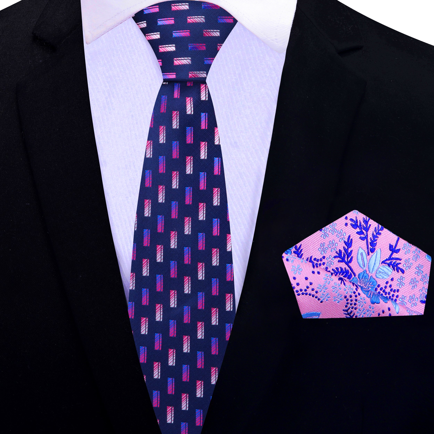 A necktie with a geometric check pattern in blue and pink shades, displayed on a marble surface with a white dress shirt and green foliage in the background.
