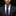 Man wearing a dark suit with a patterned tie and pocket square against a black background