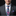 Man wearing a gray suit with a colorful floral tie and pocket square on a black background