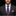 Man wearing a dark suit with a colorful tie and orange pocket square on a black background
