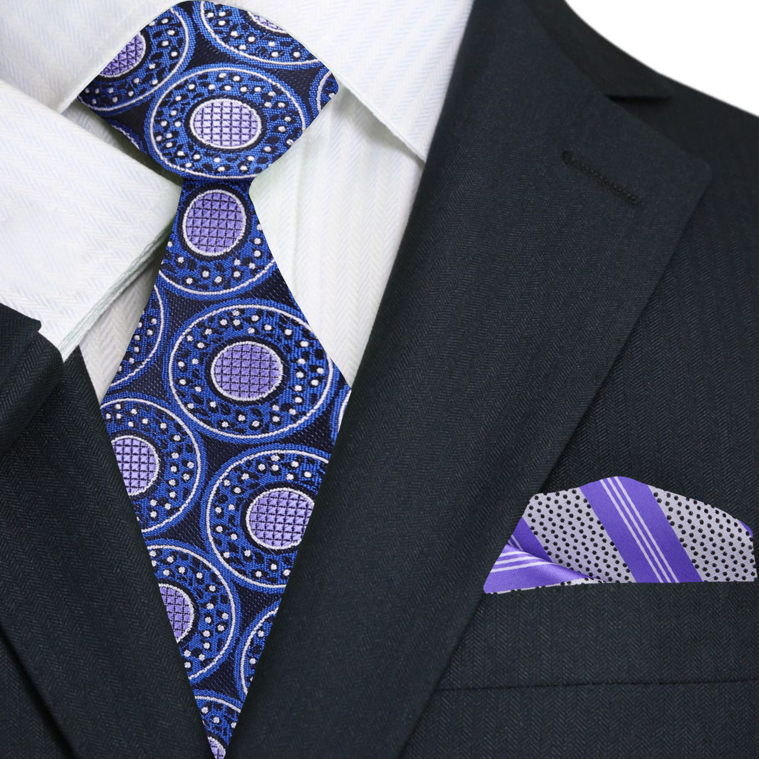 Black suit with a blue and purple patterned tie and pocket square.