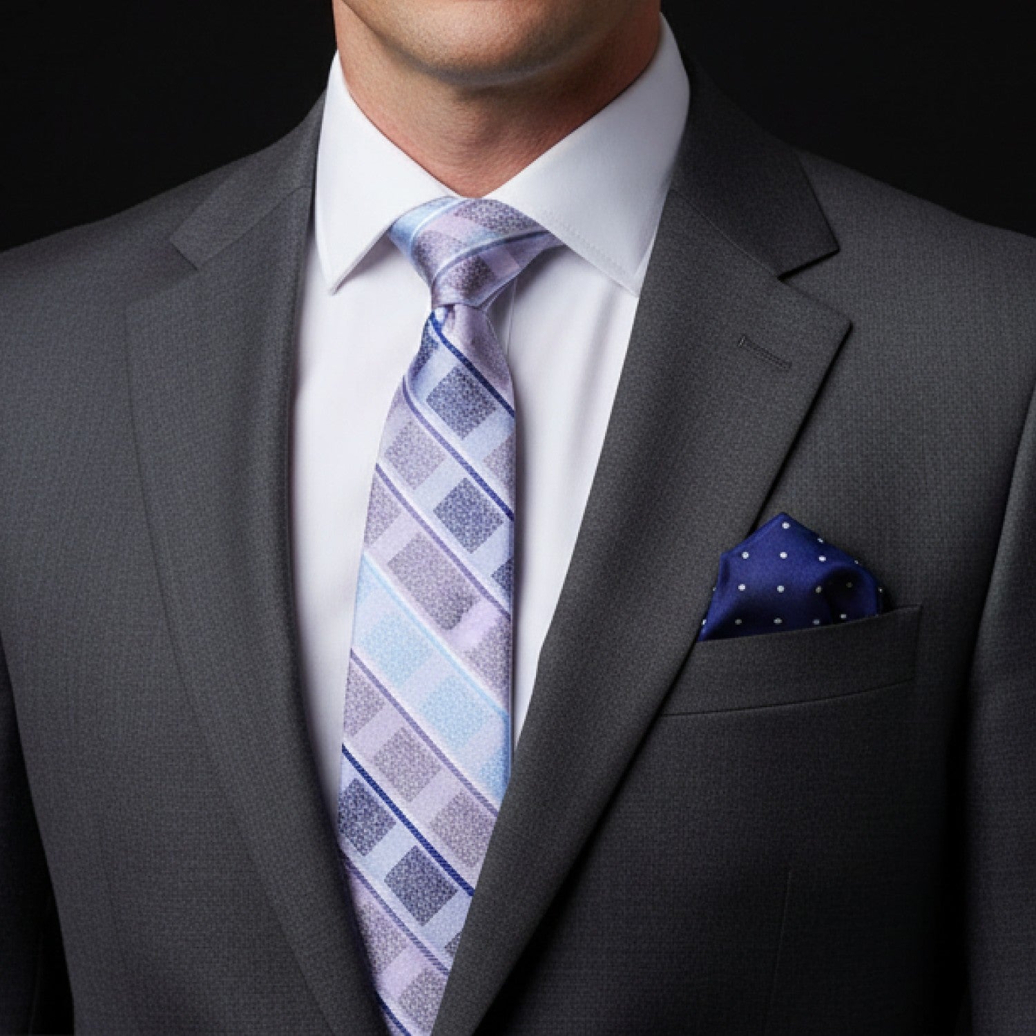 Gray suit with a patterned tie and pocket square on a black background