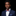 Man wearing a navy suit with a colorful bow tie on a black background