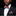 Man wearing a black suit with a colorful bow tie and pocket square against a black background
