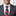 Man wearing a gray suit with a red, white, and blue tie and pocket square.