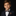 Young boy in a suit with a patterned bow tie and pocket square on a black background