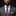 Man wearing a gray suit with a patterned tie on a black background