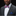 Man wearing a gray suit with a colorful bow tie and blue pocket square on a black background